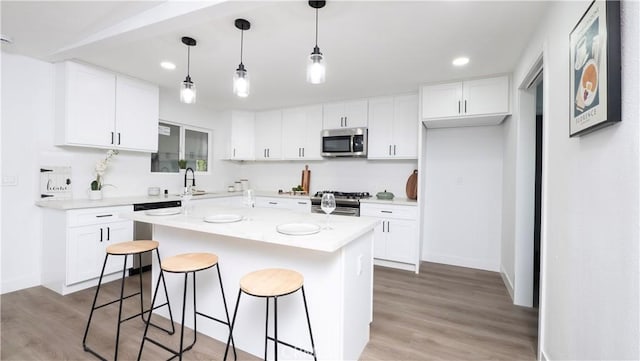 kitchen featuring a center island, sink, light hardwood / wood-style flooring, stainless steel appliances, and white cabinets