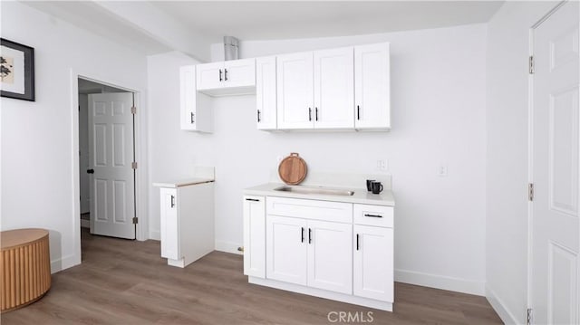 kitchen with white cabinets, wood-type flooring, and sink