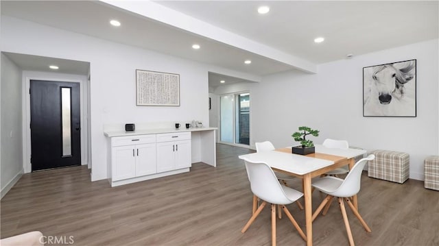 dining space with dark hardwood / wood-style flooring and beam ceiling