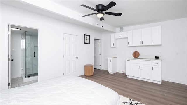 bedroom featuring ceiling fan, connected bathroom, and hardwood / wood-style flooring