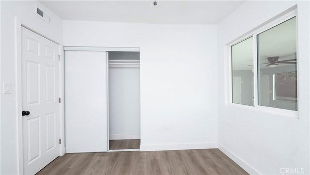 unfurnished bedroom featuring a closet and light hardwood / wood-style floors