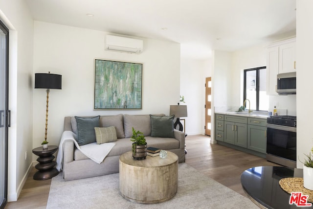 living room featuring hardwood / wood-style floors, sink, and a wall mounted air conditioner