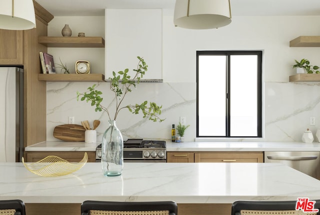 kitchen with refrigerator, decorative backsplash, range, stainless steel dishwasher, and light stone counters