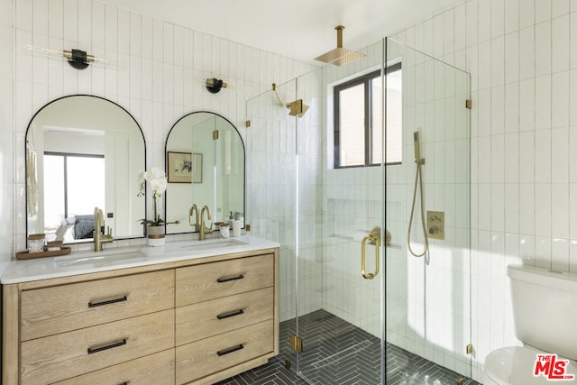 bathroom with walk in shower, vanity, tile walls, and tile patterned flooring