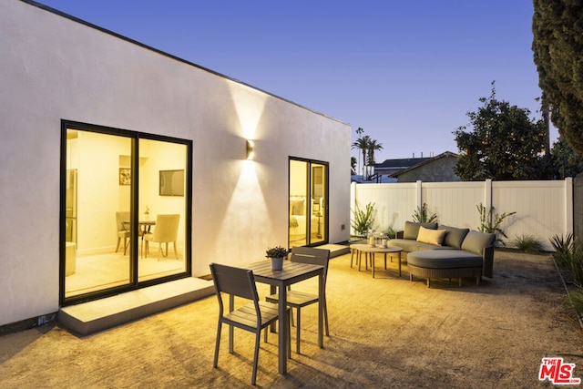 patio terrace at dusk featuring an outdoor hangout area