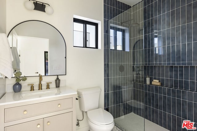 bathroom featuring toilet, an enclosed shower, and vanity