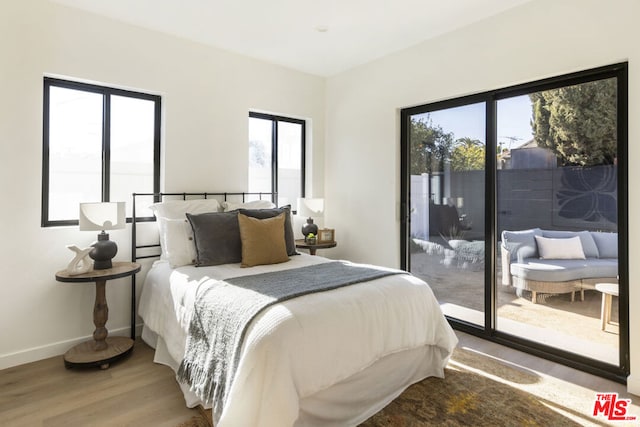 bedroom featuring access to exterior and wood-type flooring