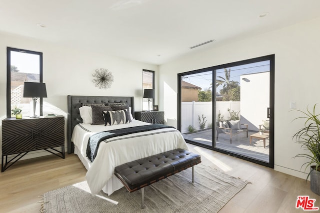 bedroom featuring access to exterior and light hardwood / wood-style floors