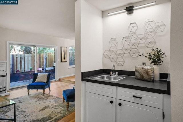 kitchen with sink, white cabinetry, and light hardwood / wood-style floors