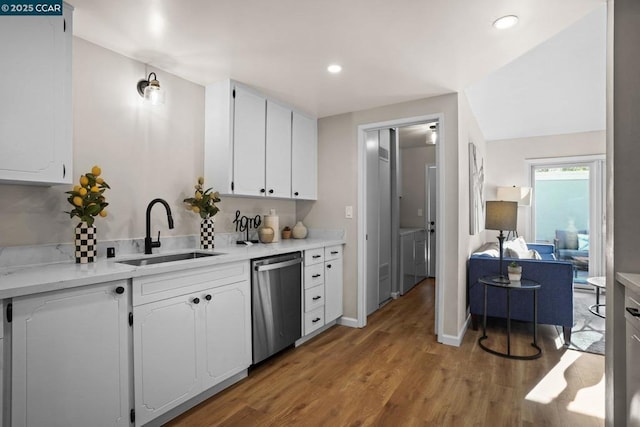 kitchen featuring sink, white cabinetry, dishwasher, lofted ceiling, and light wood-type flooring