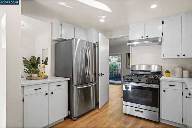 kitchen featuring white cabinets, stainless steel appliances, and light wood-type flooring