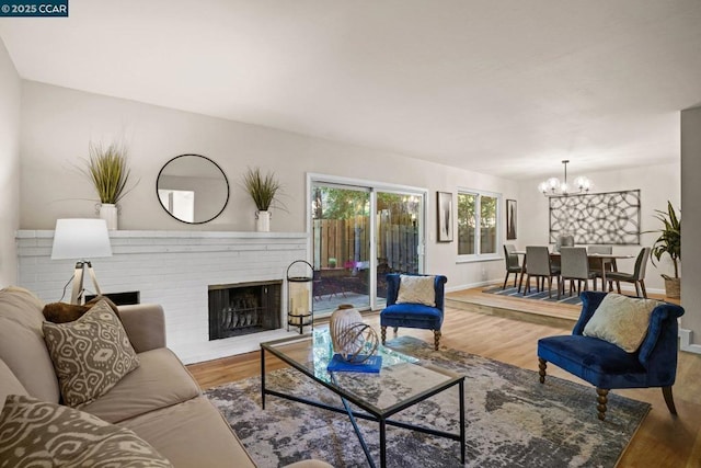 living room featuring a fireplace, hardwood / wood-style floors, and a notable chandelier