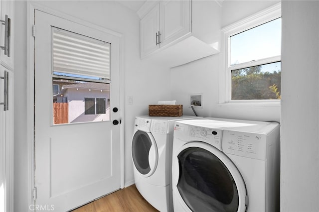 clothes washing area featuring light hardwood / wood-style floors and washer and clothes dryer