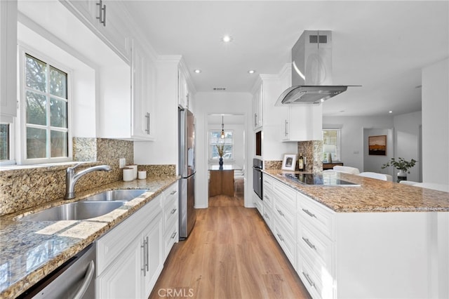 kitchen with extractor fan, light wood-type flooring, black appliances, white cabinets, and sink