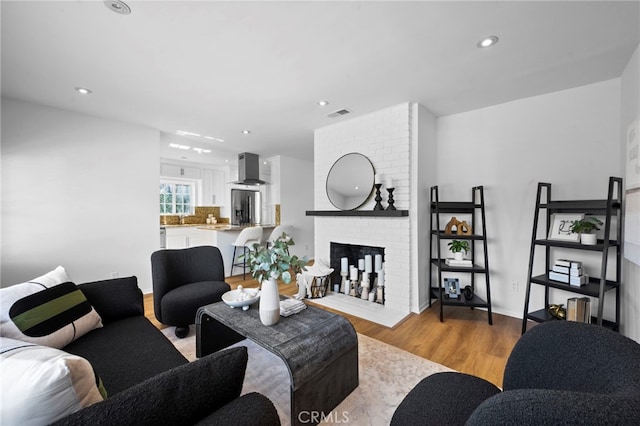 living room with light wood-type flooring and a fireplace