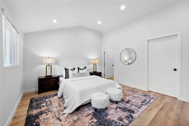 bedroom featuring lofted ceiling and light hardwood / wood-style flooring