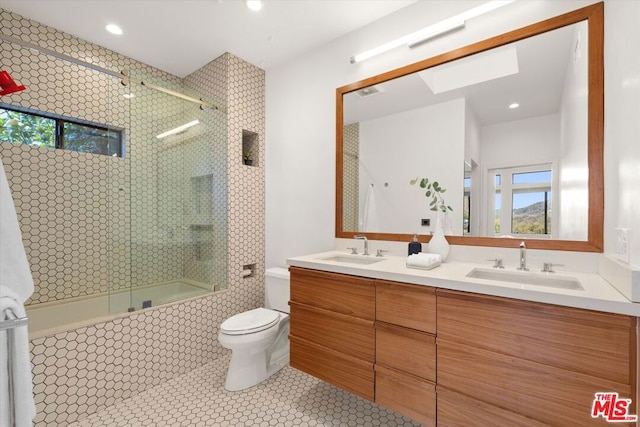 full bathroom with tile patterned floors, shower / bath combination with glass door, vanity, and toilet