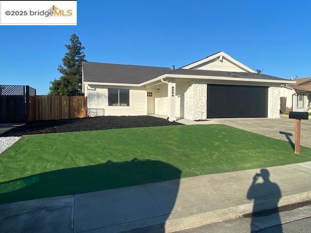 ranch-style house featuring a front yard and a garage