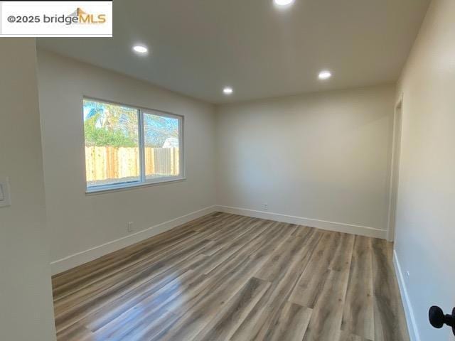 unfurnished room with wood-type flooring