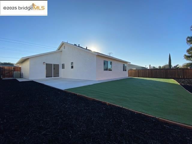 back of house featuring a yard and a patio