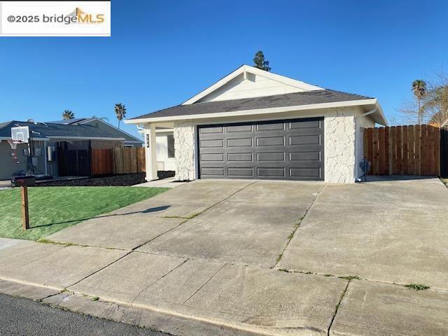 ranch-style home featuring a garage and a front lawn