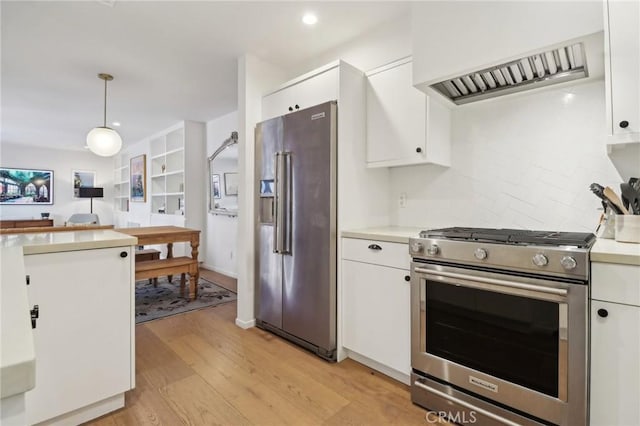 kitchen featuring decorative light fixtures, white cabinets, tasteful backsplash, and stainless steel appliances