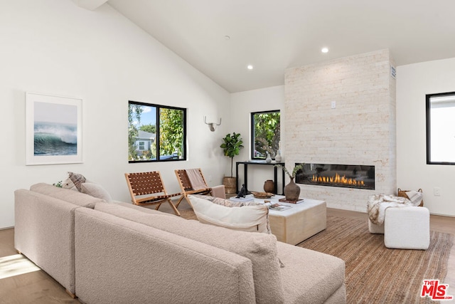 living room featuring a fireplace, high vaulted ceiling, plenty of natural light, and hardwood / wood-style floors