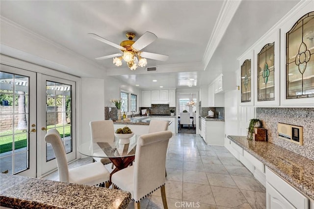 dining room with french doors, light tile patterned floors, crown molding, ceiling fan, and sink