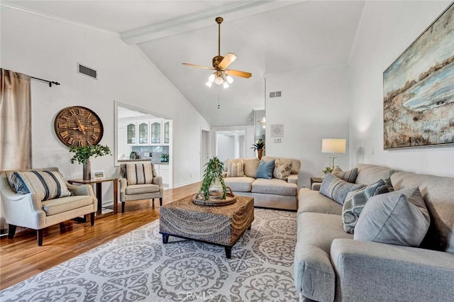 living room with high vaulted ceiling, ceiling fan, beam ceiling, and light hardwood / wood-style flooring