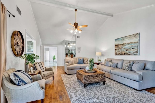 living room with light wood-type flooring, crown molding, high vaulted ceiling, beam ceiling, and ceiling fan with notable chandelier