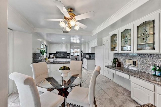 dining area featuring ceiling fan, ornamental molding, and sink