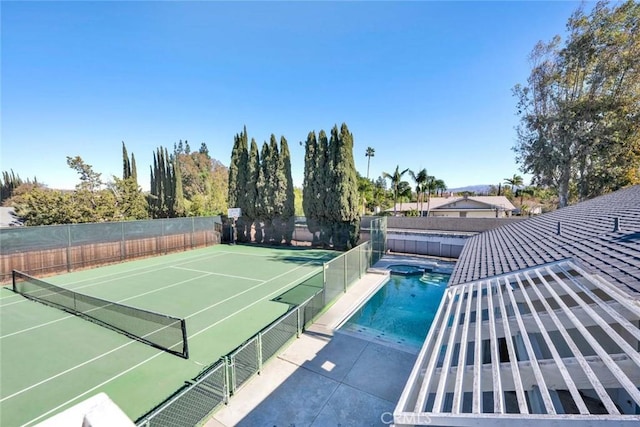 view of tennis court with a fenced in pool