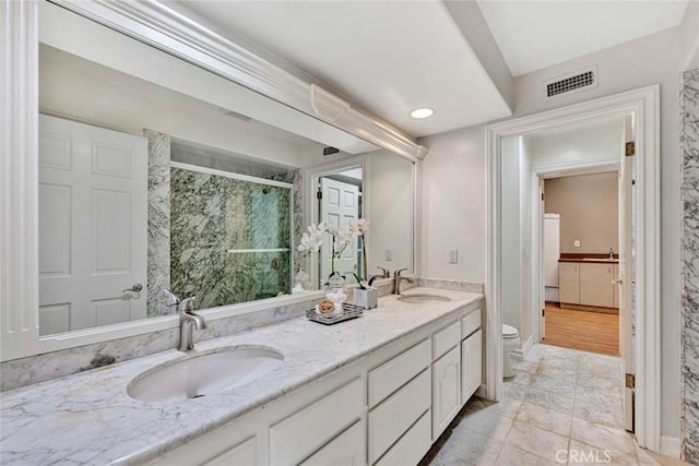 bathroom featuring toilet, walk in shower, and vanity