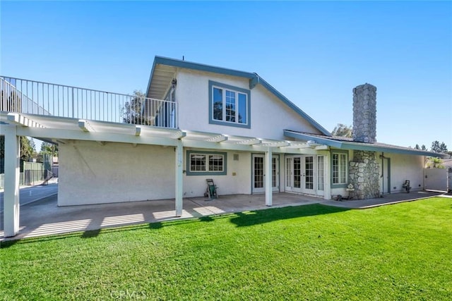 rear view of property featuring french doors, a yard, a pergola, and a patio