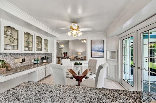 tiled dining space featuring french doors, ceiling fan, and ornamental molding