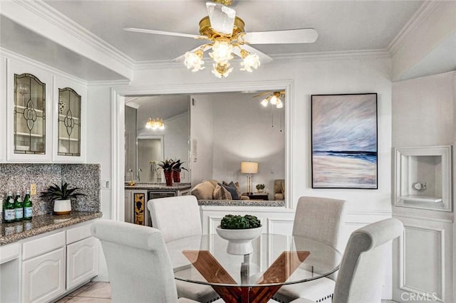 tiled dining area with an inviting chandelier and crown molding