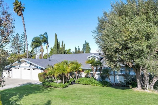 view of front of property featuring a front yard and a garage