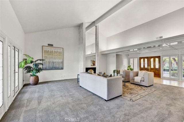 living room featuring beam ceiling, high vaulted ceiling, french doors, and carpet