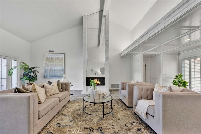 living room featuring lofted ceiling and a fireplace