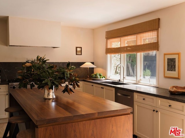 kitchen with dishwasher, a center island, butcher block counters, a breakfast bar area, and sink