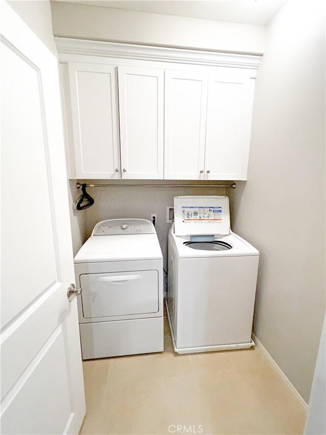 laundry area with cabinets and washer and clothes dryer