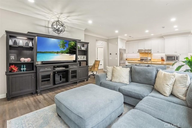 living room with ornamental molding, dark hardwood / wood-style floors, and an inviting chandelier