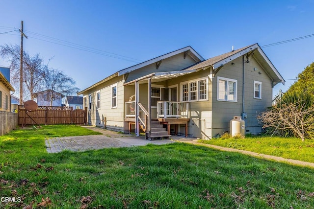 back of property with a yard and a patio