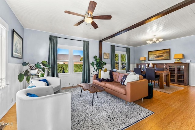 living room with beam ceiling, light hardwood / wood-style flooring, and ceiling fan with notable chandelier