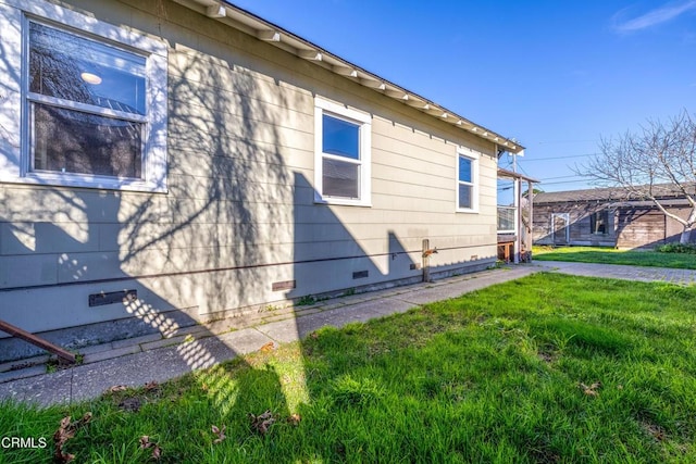 view of side of home with a yard