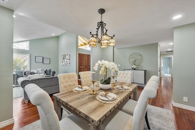 dining room featuring vaulted ceiling, dark wood-type flooring, and an inviting chandelier