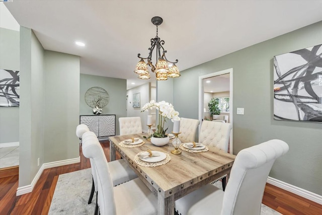 dining space with dark wood-type flooring and a chandelier