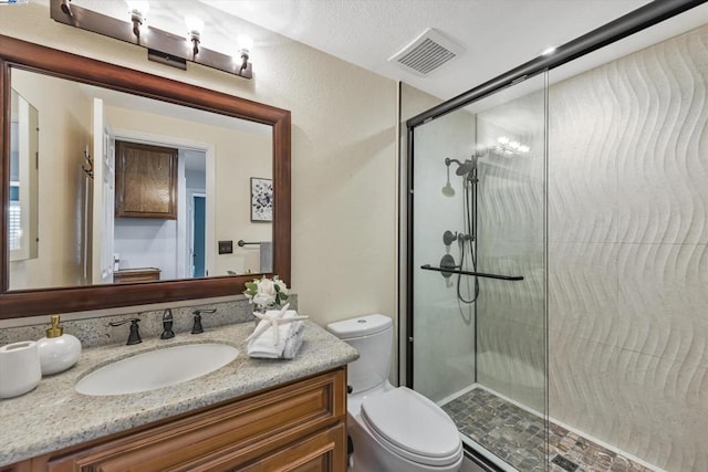 bathroom featuring toilet, vanity, and an enclosed shower