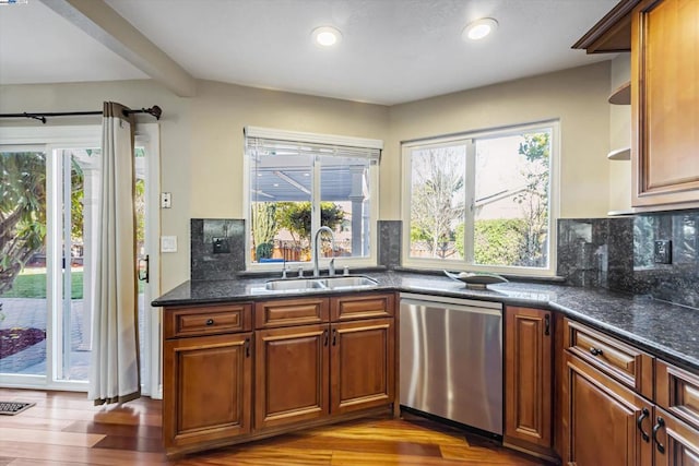 kitchen featuring a healthy amount of sunlight, decorative backsplash, dark hardwood / wood-style floors, stainless steel dishwasher, and sink