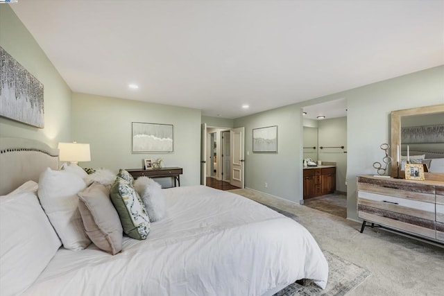 bedroom with light colored carpet and ensuite bath